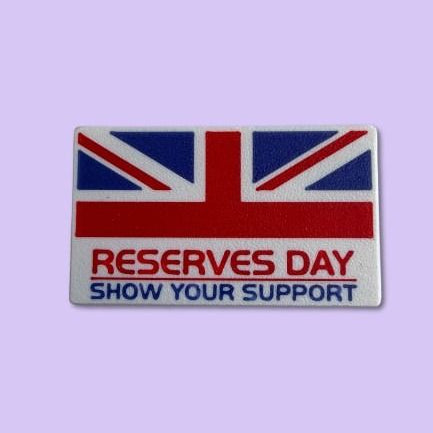 Flag patch with 'RESERVES DAY SHOW YOUR SUPPORT' text on a light purple background